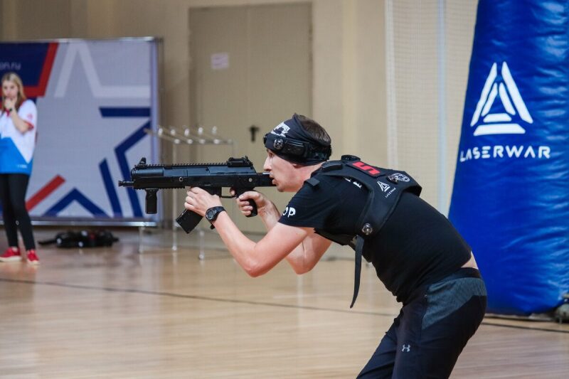 Боец LASERWAR в прицеле у синего надувного препятствия.